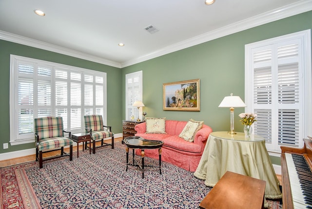 living area featuring recessed lighting, baseboards, visible vents, and ornamental molding