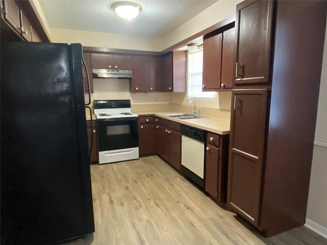 kitchen with under cabinet range hood, electric range, a sink, freestanding refrigerator, and dishwasher