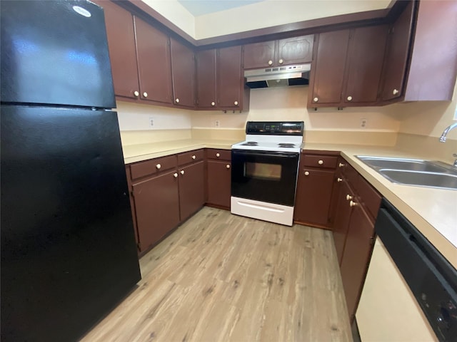 kitchen featuring electric range, freestanding refrigerator, white dishwasher, a sink, and under cabinet range hood