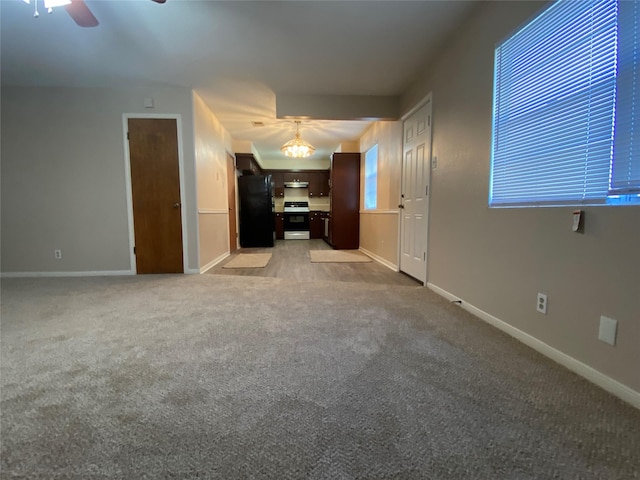 unfurnished living room featuring light carpet, a ceiling fan, and baseboards