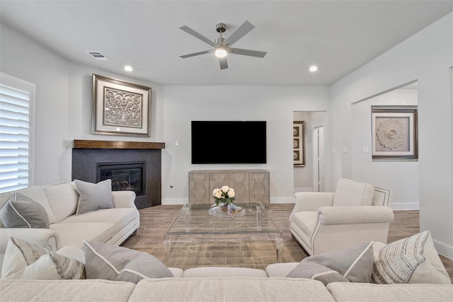 living room with a glass covered fireplace, baseboards, and recessed lighting