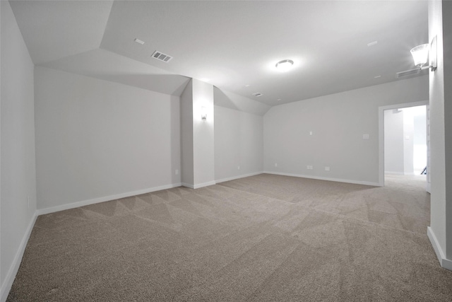 bonus room featuring lofted ceiling, baseboards, light carpet, and visible vents