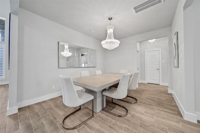 dining space featuring baseboards, visible vents, and wood tiled floor