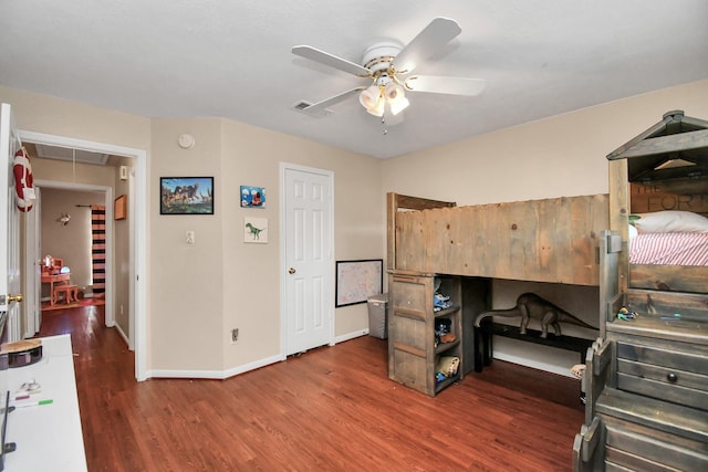 bedroom with attic access, baseboards, visible vents, ceiling fan, and wood finished floors