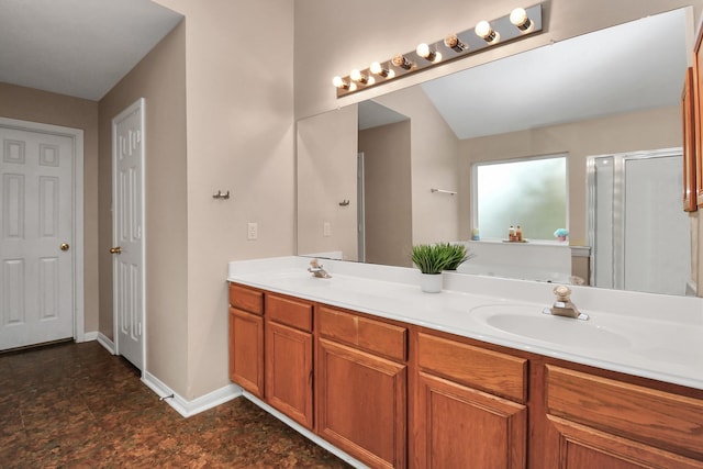 full bathroom with double vanity, baseboards, and a sink