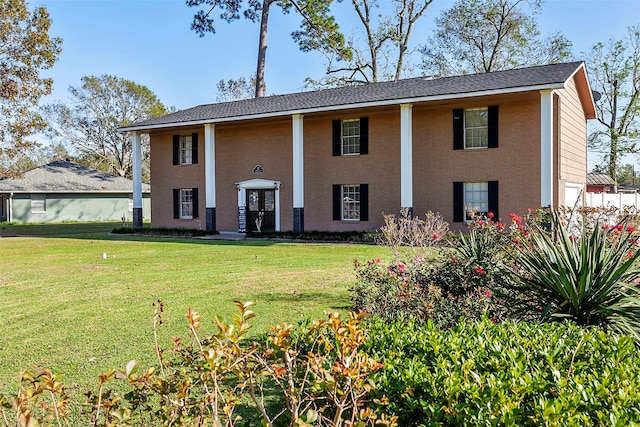 neoclassical home featuring a front lawn