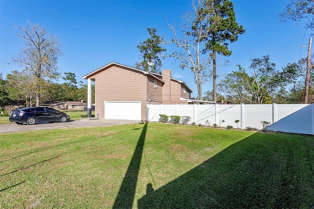 view of side of home with a yard, fence, and driveway