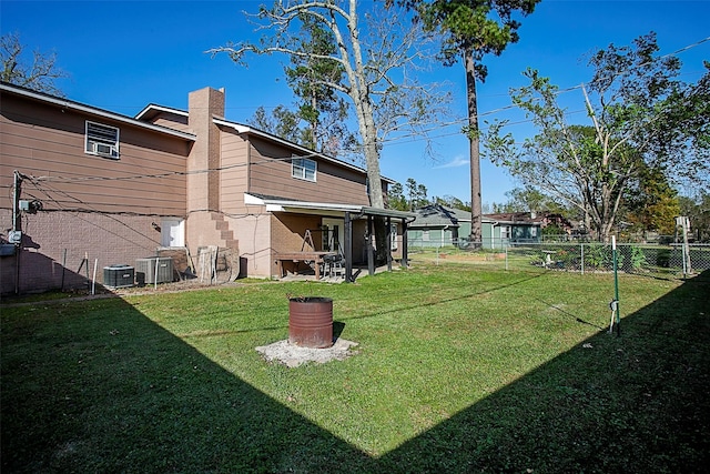 view of yard featuring fence and central air condition unit