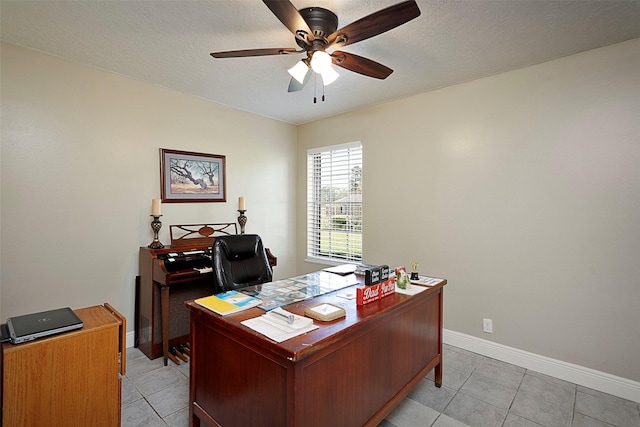 office area featuring a ceiling fan, light tile patterned flooring, a textured ceiling, and baseboards