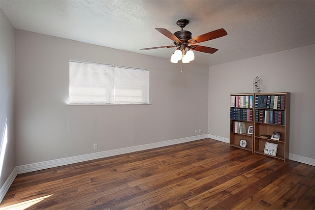 spare room with hardwood / wood-style flooring, a ceiling fan, baseboards, and a textured ceiling