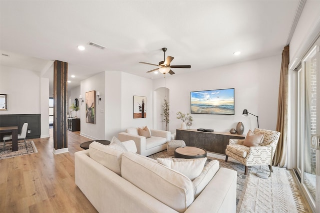 living room with light wood-type flooring, ceiling fan, visible vents, and recessed lighting