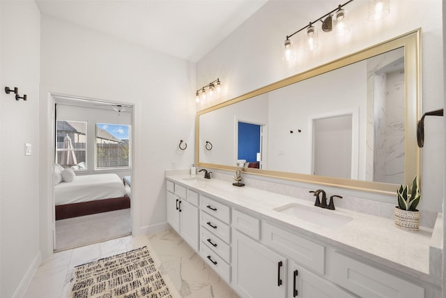 ensuite bathroom featuring marble finish floor, double vanity, a sink, and ensuite bathroom