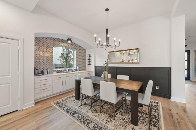 dining room featuring lofted ceiling, light wood-style floors, and plenty of natural light