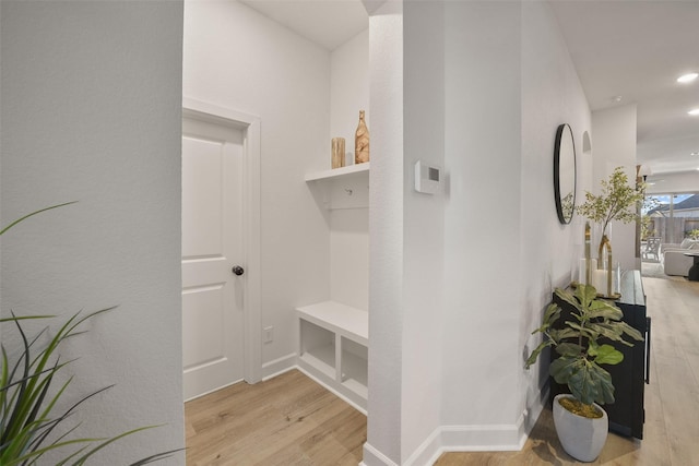 hallway with recessed lighting, light wood-style flooring, and baseboards