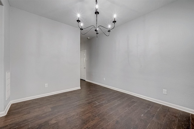 unfurnished dining area with baseboards, a chandelier, and dark wood-style flooring