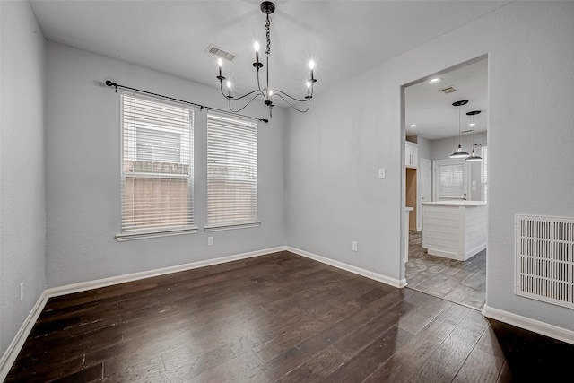 unfurnished dining area with dark wood-style flooring, visible vents, and baseboards