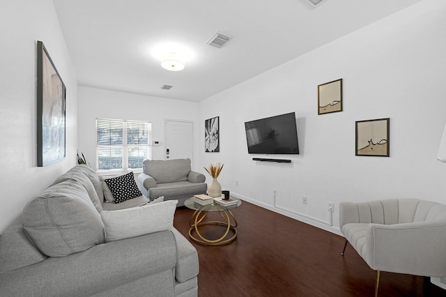 living area with visible vents, baseboards, and wood finished floors