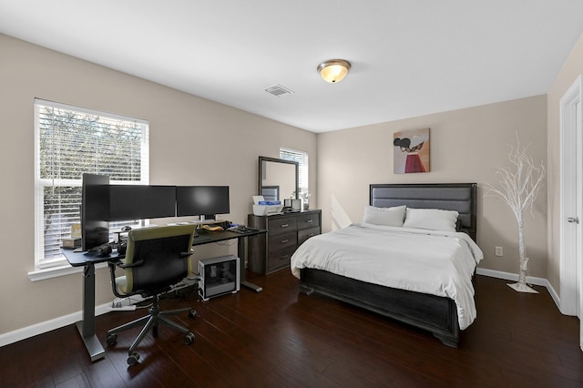 bedroom featuring multiple windows, baseboards, and hardwood / wood-style flooring