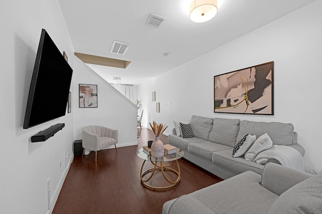 living room with visible vents, baseboards, and wood finished floors