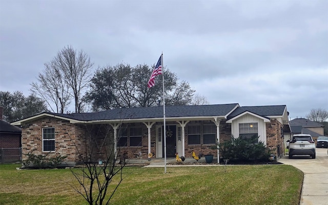 ranch-style house with board and batten siding, brick siding, a porch, and a front lawn