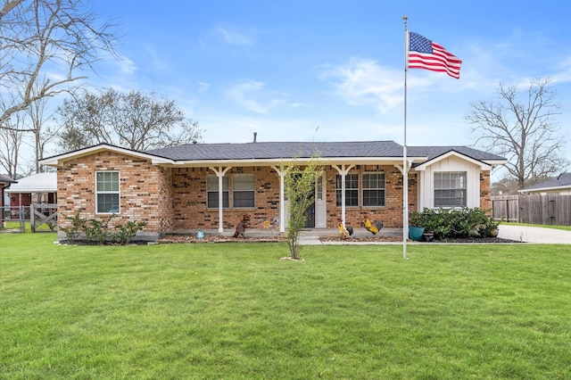 ranch-style house with brick siding, covered porch, a front lawn, and fence