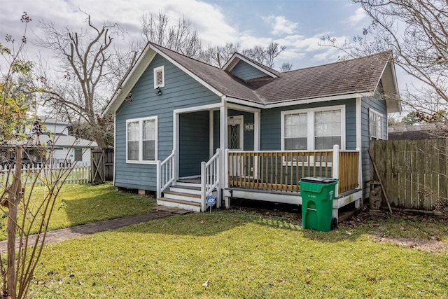 bungalow with a porch, a front yard, roof with shingles, and fence