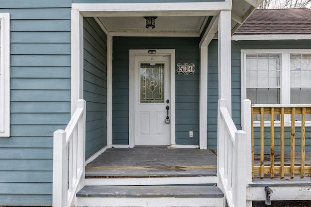 property entrance featuring a shingled roof