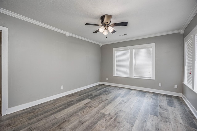 spare room featuring ornamental molding, visible vents, dark wood finished floors, and baseboards