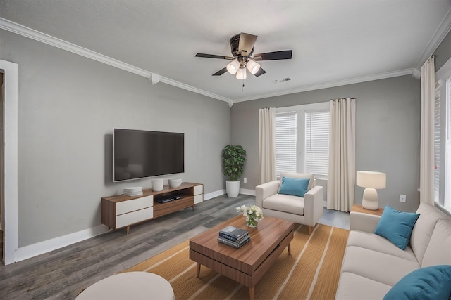 living area featuring baseboards, wood finished floors, visible vents, and crown molding