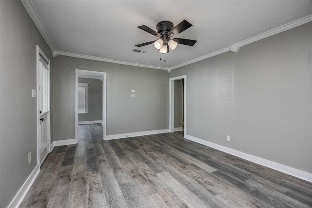 empty room featuring a ceiling fan, visible vents, ornamental molding, and wood finished floors