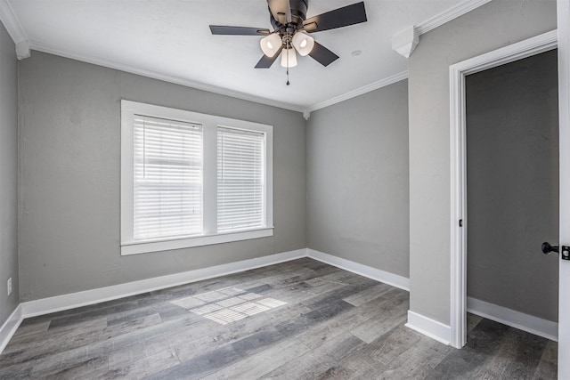 spare room featuring ornamental molding, a ceiling fan, baseboards, and wood finished floors