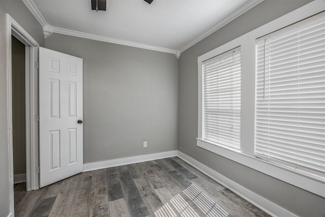 unfurnished bedroom featuring baseboards, crown molding, and wood finished floors