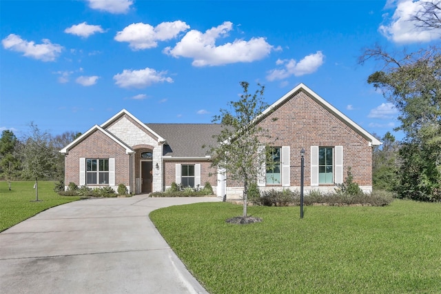 single story home with driveway, a front yard, and brick siding