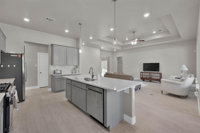 kitchen with stainless steel appliances, gray cabinets, visible vents, and a sink