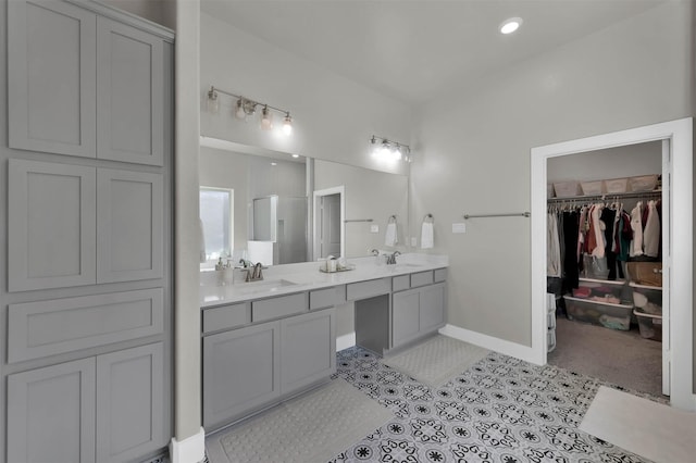 full bathroom featuring tile patterned flooring, a sink, a spacious closet, and double vanity