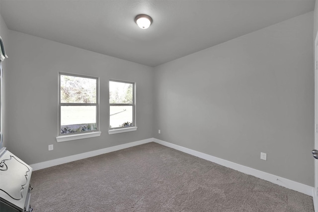 spare room featuring baseboards and carpet flooring