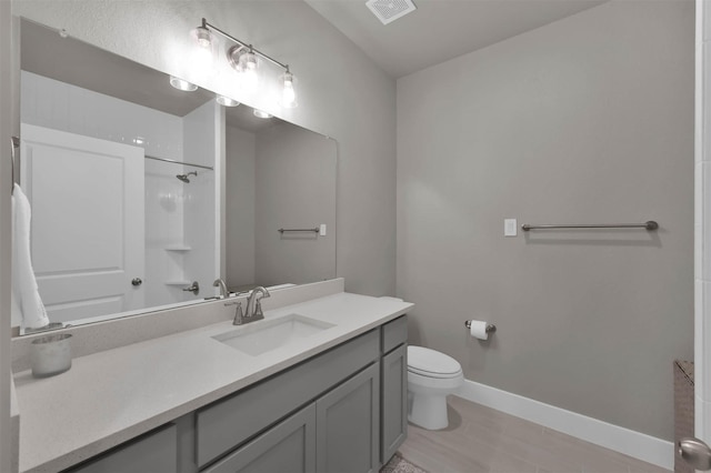 bathroom with visible vents, toilet, vanity, baseboards, and walk in shower