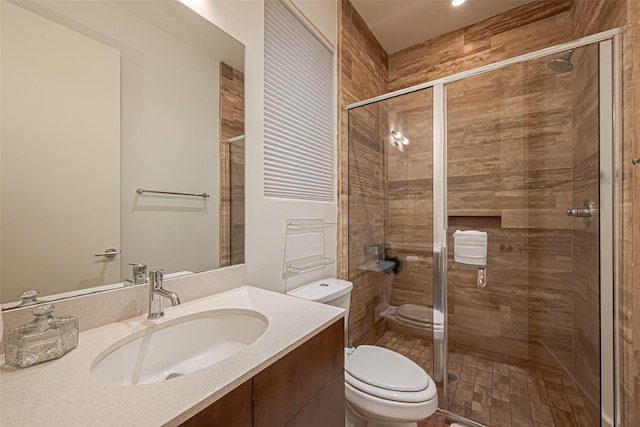 full bathroom with toilet, a shower stall, and vanity