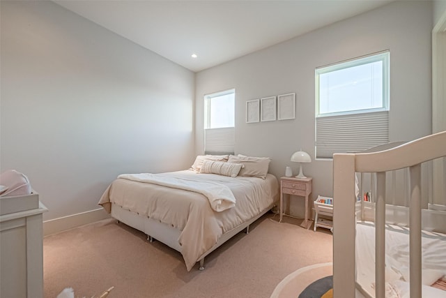 bedroom with recessed lighting, light carpet, and baseboards