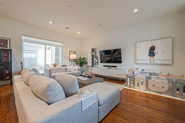 living room with recessed lighting, visible vents, and wood finished floors