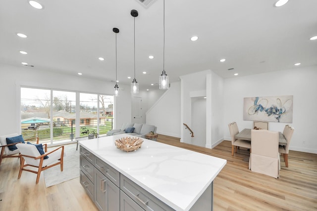 kitchen with light wood finished floors, a center island, decorative light fixtures, gray cabinetry, and recessed lighting