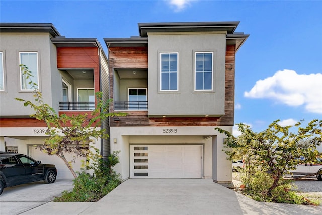 view of front of house with a garage, concrete driveway, and stucco siding