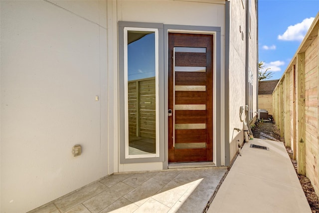 property entrance featuring fence and a patio