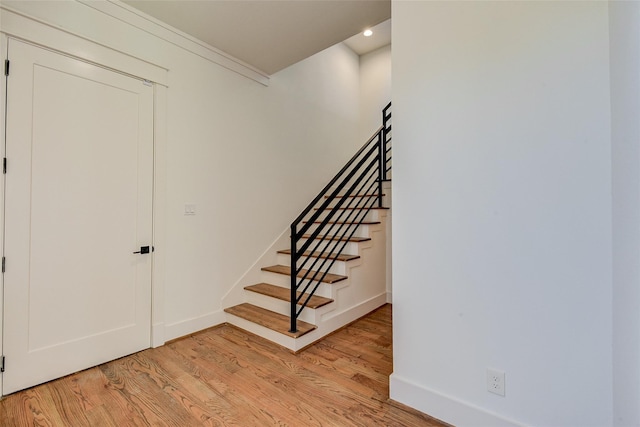 stairway with baseboards, wood finished floors, and recessed lighting