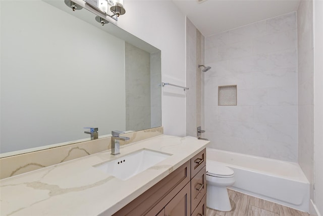 bathroom featuring toilet, tub / shower combination, wood finished floors, and vanity