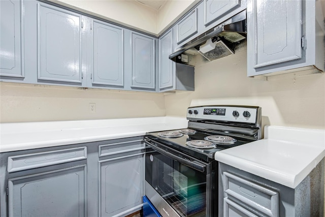 kitchen with under cabinet range hood, stainless steel electric range oven, gray cabinets, and light countertops