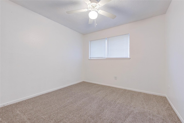 carpeted spare room with a textured ceiling, baseboards, and a ceiling fan