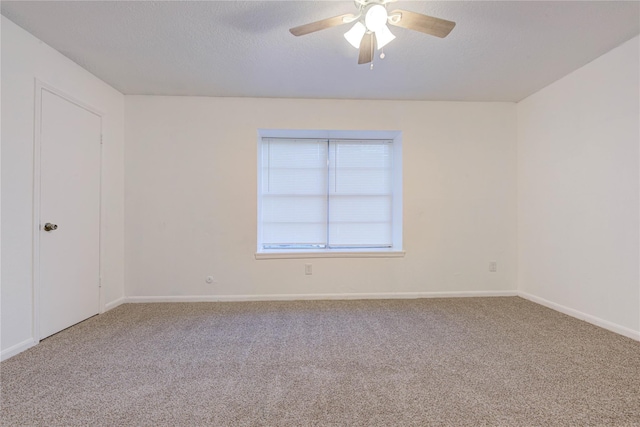 empty room with ceiling fan, a textured ceiling, baseboards, and carpet flooring