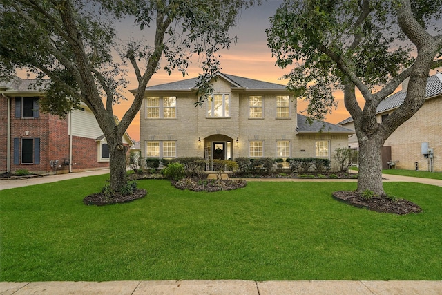 view of front facade featuring brick siding and a front yard