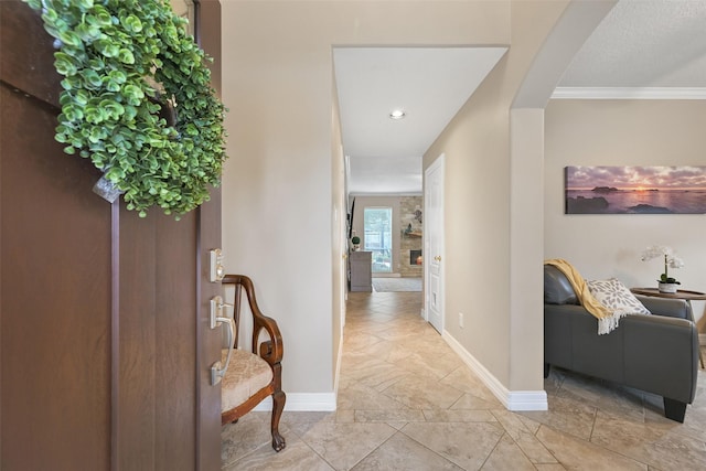 corridor with baseboards, arched walkways, and crown molding